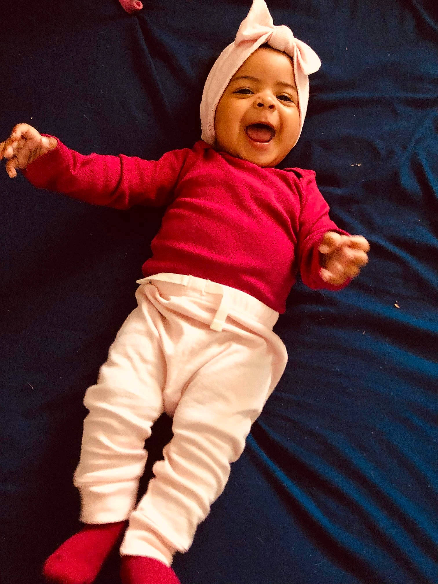 Angela is registered to the contest to win money with this photo: baby, baby_laughing, baby_toddler_clothing, child, face, fictional_character, fun, gesture, happy, hat, headwear, human_body, laugh, long_sleeved_t_shirt, magenta, person, play, sleeve, smile, t_shirt