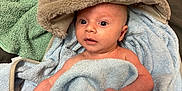 Marshall is registered to the contest to win money with this photo: baby, towel, bear_hood, soft_texture, blue_towel, green_towel, phone, curious_expression, infant, wrapped, cute, indoors, blanket, newborn, skin, face, headwear, child, sleepwear, plush