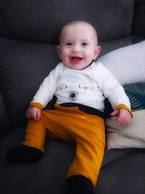 Simon participe au concours pour gagner de l'argent avec cette photo : baby, baby_toddler_clothing, cheek, child, chin, comfort, couch, eye, flash_photography, floor, fun, happy, head, iris, outerwear, person, skin, sleeve, smile, t_shirt