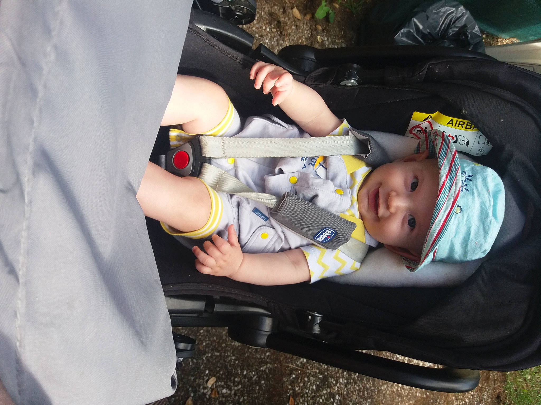 Simon participe au concours pour gagner de l'argent avec cette photo : auto_part, baby, baby_carriage, baby_products, baby_safety, baby_toddler_clothing, car_seat, child, comfort, fun, gesture, grass, headwear, joy, lap, person, recreation, sitting, smile, tire