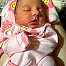 newborn, baby, sleeping, pink_clothing, flamingo_pattern, blanket, floral_pattern, infant, cozy, cute, soft, face, closed_eyes, resting, child, person, indoors, comfort, warmth, portrait