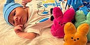 Zaiden is registered to the contest to win money with this photo: baby, bed, bodypart, cap, clothing, doll, face, finger, furniture, hand, hat, head, newborn, person, photography, plush, portrait, sleeping, teddybear, toy