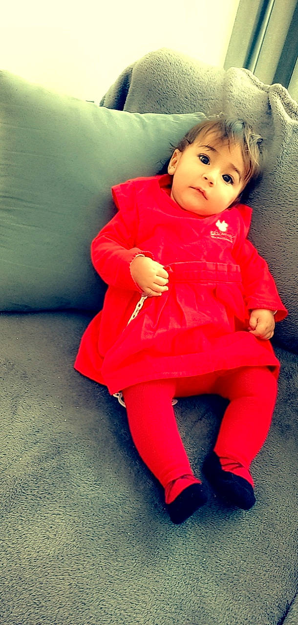 Juliette participe au concours pour gagner de l'argent avec cette photo : baby_toddler_clothing, cheek, comfort, couch, dress, eye, face, flooring, fun, hair, happy, head, human_body, human_leg, lip, magenta, one_piece_garment, person, skin, sleeve