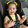 toddler, child, car_seat, yellow_bows, yellow_dress, smiling, snack, seatbelt, safety, car_interior, cute, happy, baby, hair_bows, child_safety, portrait, young_child, seat, baby_girl, indoors
