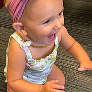 Chloe is registered to the contest to win money with this photo: arm, baby, carpet, child, clothing, cute, expression, floor, hand, happy, headband, indoor, kneeling, laughing, person, pink, playful, smiling, toddler, young