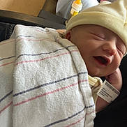 Trevin is registered to the contest to win money with this photo: baby, blanket, bottle, care, clothing, comfort, couch, hat, holding, hospital, indoor, infant, newborn, parent, person, relaxation, resting, sleeping, smile, wristband