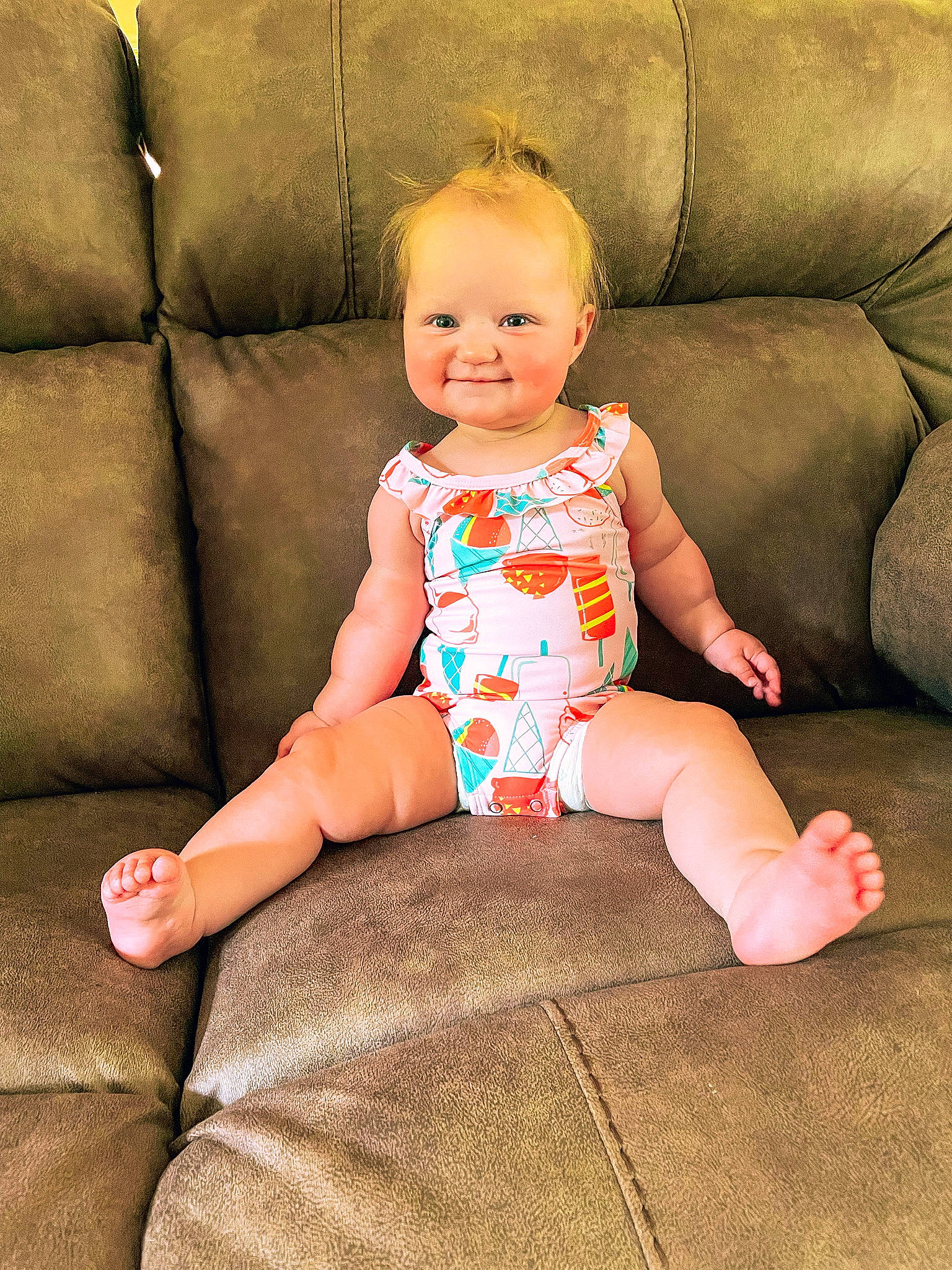 Sutton is registered to the contest to win money with this photo: arm, baby_toddler_clothing, cheek, comfort, couch, eye, facial_expression, finger, hairstyle, head, human_body, joint, joy, leg, neck, person, pink, skin, sleeve, smile