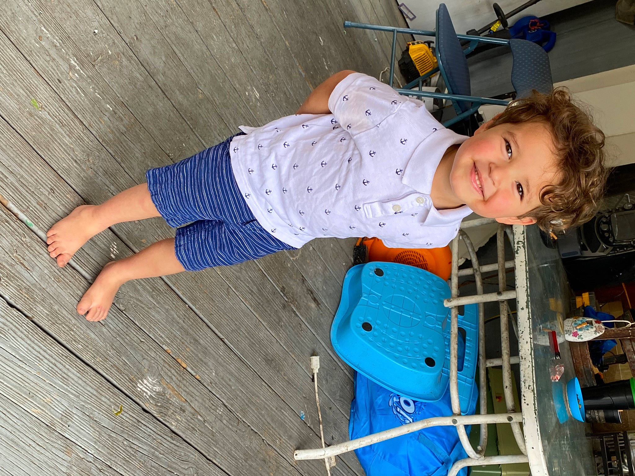 Eli is registered to the contest to win money with this photo: automotive_exterior, baby_toddler_clothing, child, electric_blue, flooring, fun, hardwood, joy, knee, leisure, motor_vehicle, outdoor_shoe, pattern, person, play, sitting, smile, t_shirt, tire, toddler