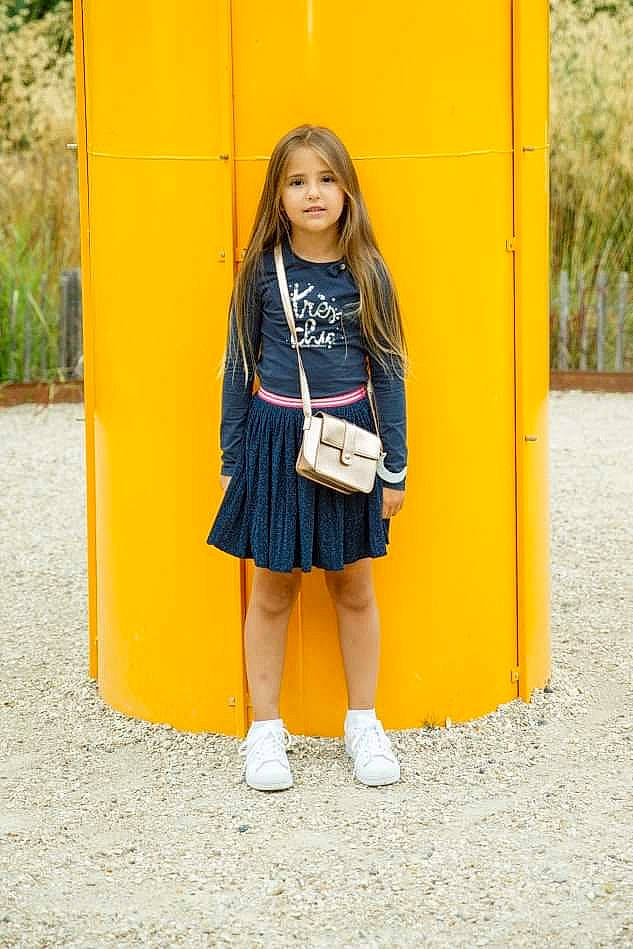 Sofia participe au concours pour gagner de l'argent avec cette photo : blond, denim, electric_blue, fun, hair, happy, knee, long_hair, orange, outerwear, person, plant, school_uniform, shoe, sleeve, smile, sportswear, street_fashion, t_shirt, thigh