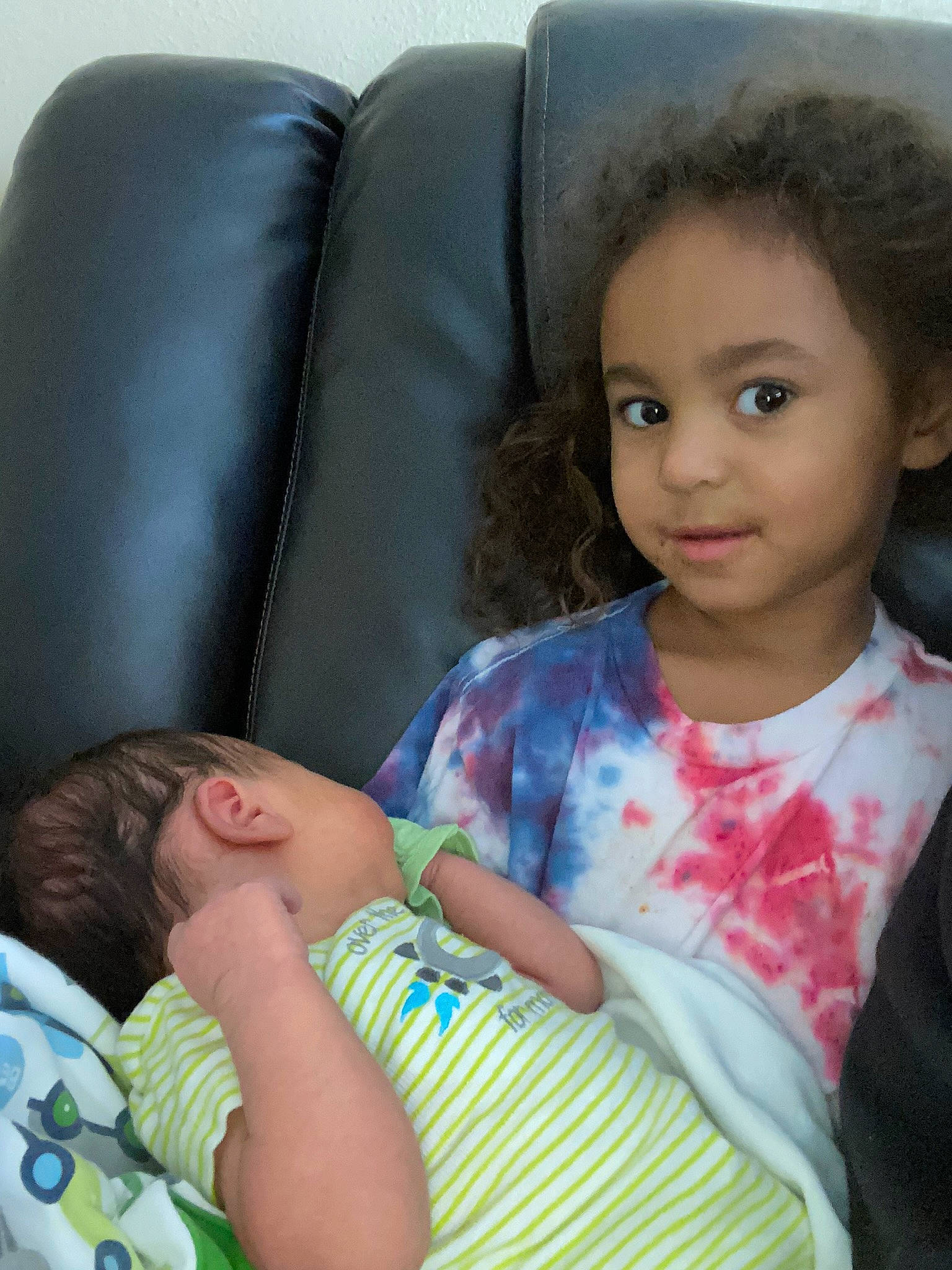 Braelyn is registered to the contest to win money with this photo: arm, baby, baby_toddler_clothing, cheek, child, comfort, couch, eye, hairstyle, happy, human_leg, iris, lap, nose, organ, person, sitting, skin, thigh, toddler