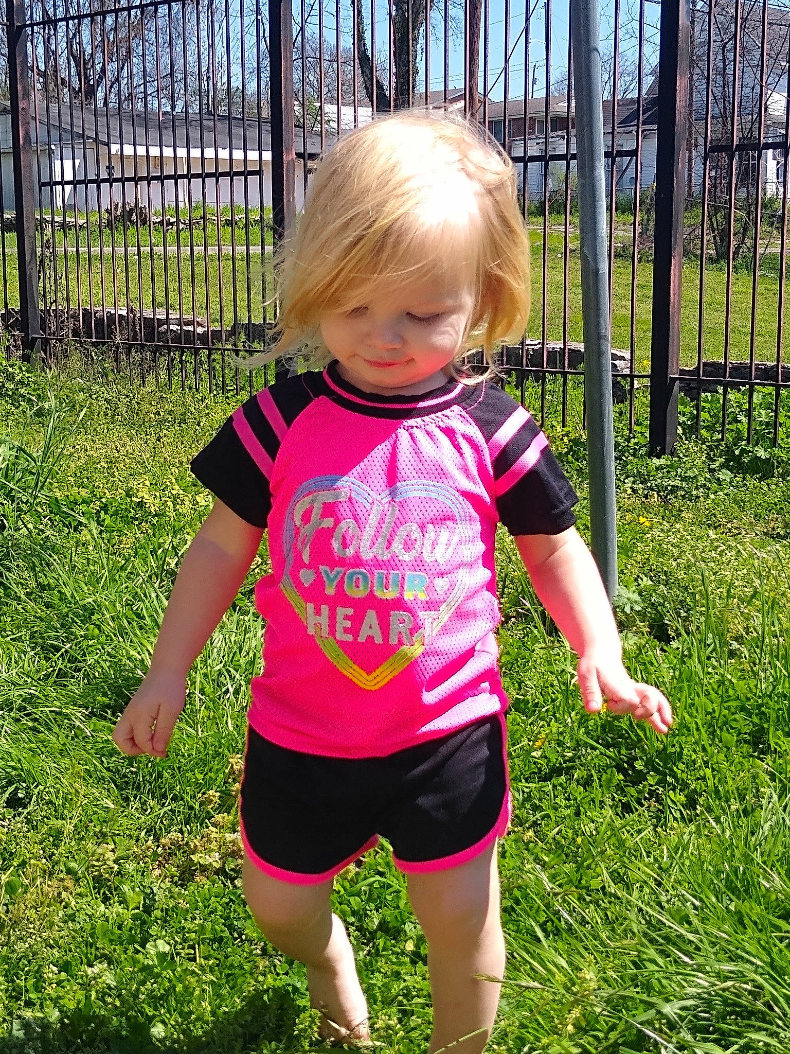 Brileigh is registered to the contest to win money with this photo: baby_toddler_clothing, fence, fun, garden, grass, grass_family, happy, leisure, pattern, people_in_nature, person, pink, plant, shorts, sky, sleeve, smile, spring, summer, t_shirt