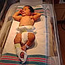 Kyra Bromell is registered to the contest to win money with this photo: newborn, baby, hospital, bassinet, blanket, diaper, ankle_bracelet, medical_boot, sleeping, infant, nursery, bed, child, person, skin, hospital_room, cotton_blanket, wrapped, resting, indoors