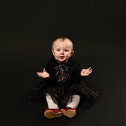 Elizabeth joined the competition — help win amazing prizes! baby, child, sitting, black_dress, red_shoes, sparkly, portrait, studio, curious, cute, expression, hands, isolated, background, infant, young_child, fashion, smile, female, indoor