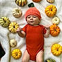 baby, infant, pumpkin_hat, orange_onesie, blanket, autumn, fall, pumpkins, cute, lying_down, cozy, seasonal, child, outdoor, holiday, festive, smiling, headwear, soft_texture, nature