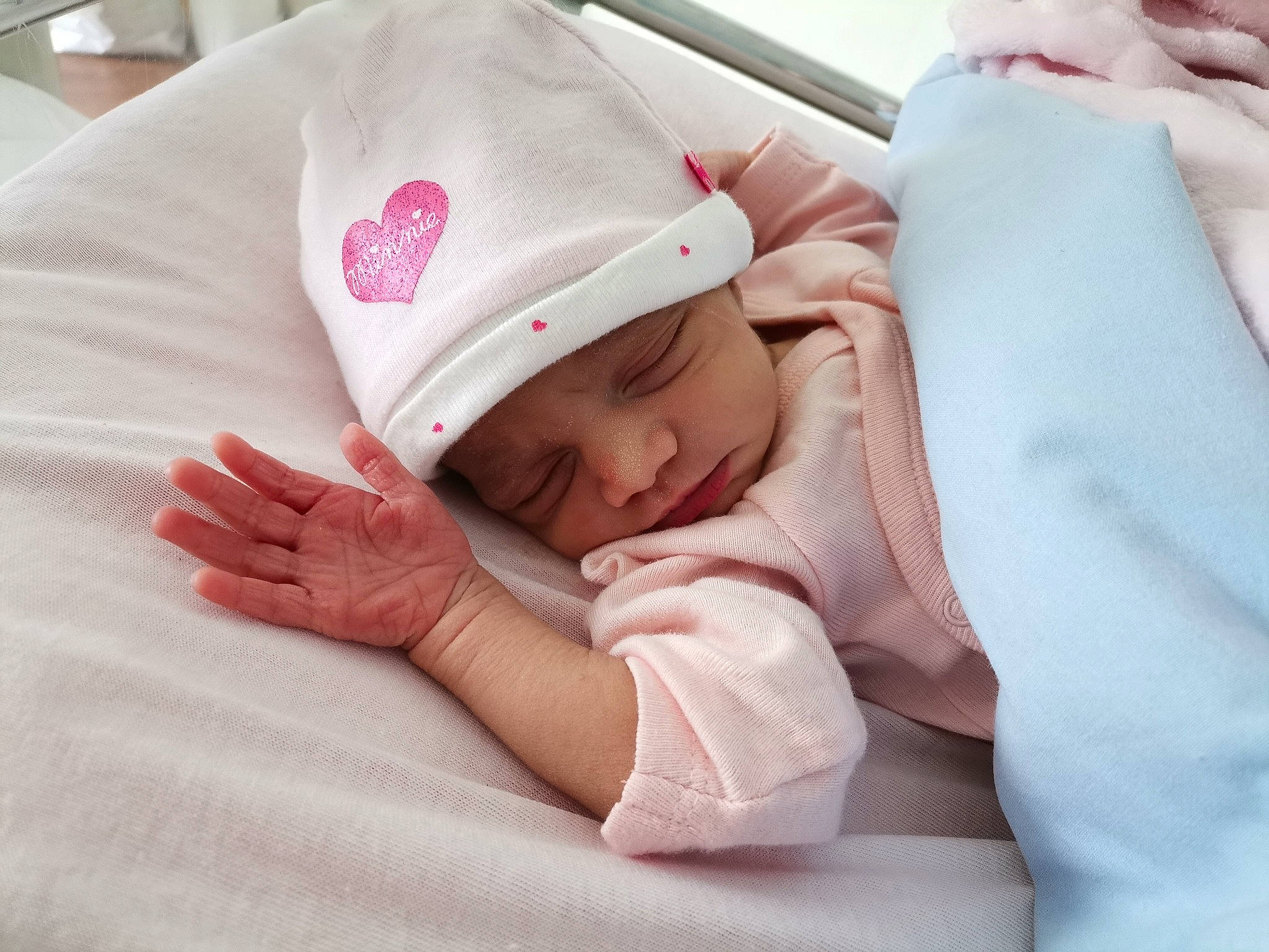 Luna a rejoint le concours — aidez-le/la à gagner de superbes lots ! baby, baby_products, baby_safety, baby_sleeping, baby_toddler_clothing, bedding, bedtime, cap, cheek, child, comfort, finger, gesture, headwear, linens, person, room, skin, sleeve, textile