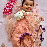 Chiara participe au concours pour gagner de l'argent avec cette photo : baby, infant, child, smile, pink, hearts, tulle, blanket, number_seven, flowers, purple_flowers, overalls, ribbed_shirt, hair_clip, portrait, laying_down, cute, milestone, studio_style, decorative_prop