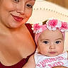 Athena is registered to the contest to win money with this photo: adult, baby, mother, child, portrait, smiling, flower_headband, pink, onesie, holding, indoors, seated, close_up, face, eyes, makeup, red_clothing, family, parenting, photography