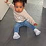 toddler, child, indoor, floor, tile_floor, sweater, jeans, white_shoes, hair_tied, cute, balancing, sitting, young_child, casual_clothing, portrait, person, baby, expression, candid, home