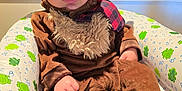 Oliver is registered to the contest to win money with this photo: animal_costume, baby, brown, child, costume, curious, cute, ears, face, frog_pattern, hand, hat, horns, indoors, inflatable_chair, legs, moose, plush, seated, soft_toys