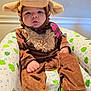 animal_costume, baby, brown, child, costume, curious, cute, ears, face, frog_pattern, hand, hat, horns, indoors, inflatable_chair, legs, moose, plush, seated, soft_toys