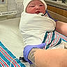 newborn, baby, hospital, blanket, hat, gloved_hand, tattoo, medical_equipment, bed, infant, person, swaddled, striped_blanket, newborn_baby, patient, healthcare, bedside, closeup, child, fresh_born