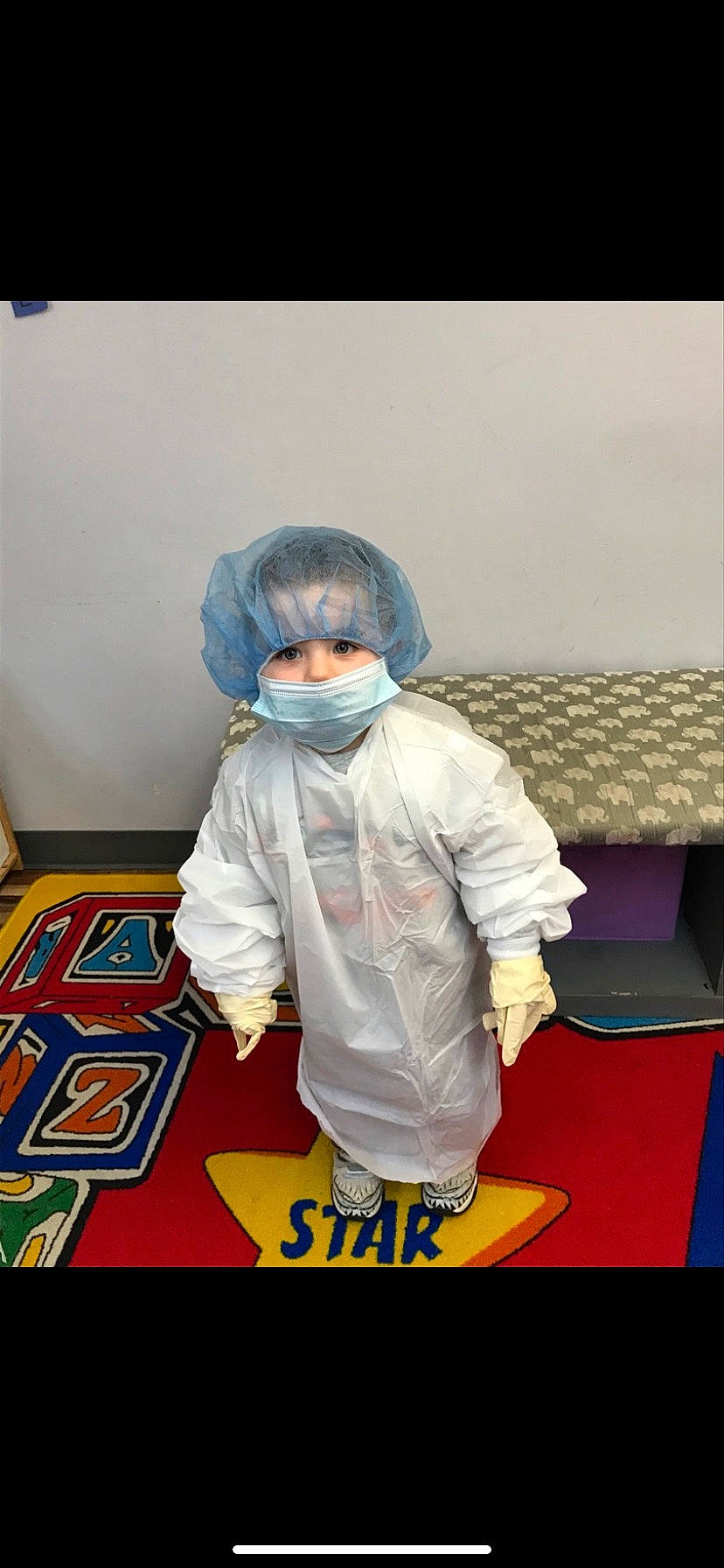 Michael is registered to the contest to win money with this photo: animation, carpet, child, costume, electric_blue, entertainment, fashion_design, fictional_character, floor, flooring, fun, fur, glove, person, personal_protective_equipment, play, room, sitting, sleeve, toddler