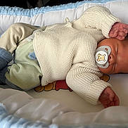 Noham a rejoint le concours — aidez-le/la à gagner de superbes lots ! baby, bassinet, blanket, blue_sock, cartoon_print, closeup, crib, cushion, face, hand, head, infant, knitted_sweater, newborn, pacifier, portrait, rest, sleeping, sock, soft_texture