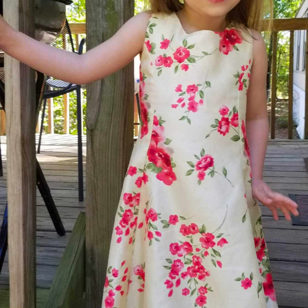 Kinzlee is registered to the contest to win money with this photo: child, child_model, clothing, day_dress, dress, formal_wear, joy, neck, pattern, peach, person, pink, plant, sleeve, textile, toddler, waist, wildflower