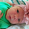 Rylee is registered to the contest to win money with this photo: baby, infant, child, portrait, close_up, face, eyes, smiling, pink, green, outfit, headband, flower, floral, blanket, lying_down, indoor, soft_lighting, cute, photography
