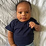 Leon joined the competition — help win amazing prizes! baby, infant, child, face, eyes, tongue, curly_hair, clothing, navy_shirt, striped_pants, lying_down, blanket, quilted, skin, hand, portrait, expression, indoors, cute, person