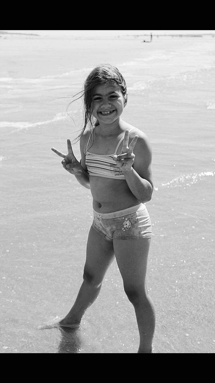 Bella a rejoint le concours — aidez-le/la à gagner de superbes lots ! abdomen, beach, body_of_water, eyewear, hair, happy, human_body, human_leg, joy, knee, leg, long_hair, people_in_nature, person, shorts, smile, style, swimwear, thigh, trunk