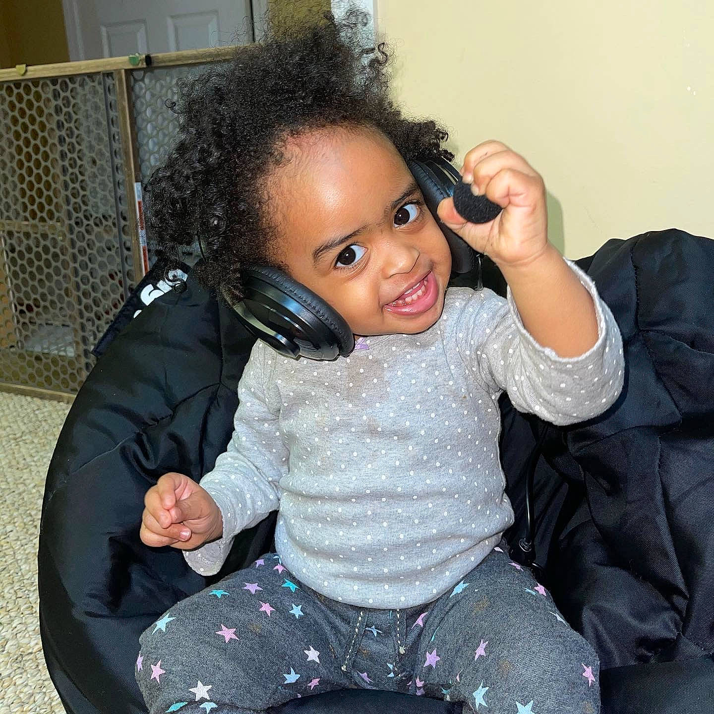 Madeleine is registered to the contest to win money with this photo: audio_equipment, baby_toddler_clothing, cheek, chin, comfort, couch, eyelash, finger, flash_photography, fun, gesture, happy, iris, joint, joy, lip, neck, person, sleeve, thigh