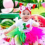 Valentina is registered to the contest to win money with this photo: baby, birthday, blanket, celebration, child, colorful, cute, decorations, festive, first_birthday, grass, greenery, happy, headband, outdoor, party, sitting, smiling, tutu, watermelon