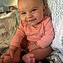 Valentina is registered to the contest to win money with this photo: baby, infant, smile, drool, onesie, pink_clothing, barefoot, bracelet, cute, happy, indoors, blanket, bed, person, child, skin, head, foot, hand, portrait