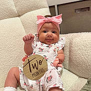 Everley joined the competition — help win amazing prizes! baby, celebration, chair, child, cozy, cute, fist_raised, floral_outfit, happy, indoor, infant, milestone_sign, pink_bow, portrait, sitting, smiling, sock, soft_texture, two_months, young_child