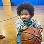 Nazir Anderson is registered to the contest to win money with this photo: toddler, child, basketball, indoor, gym, floor, curly_hair, casual_clothing, hoodie, jeans, shoe, hand, sports, playful, young_child, person, wooden_floor, ball, expression, indoor_sports