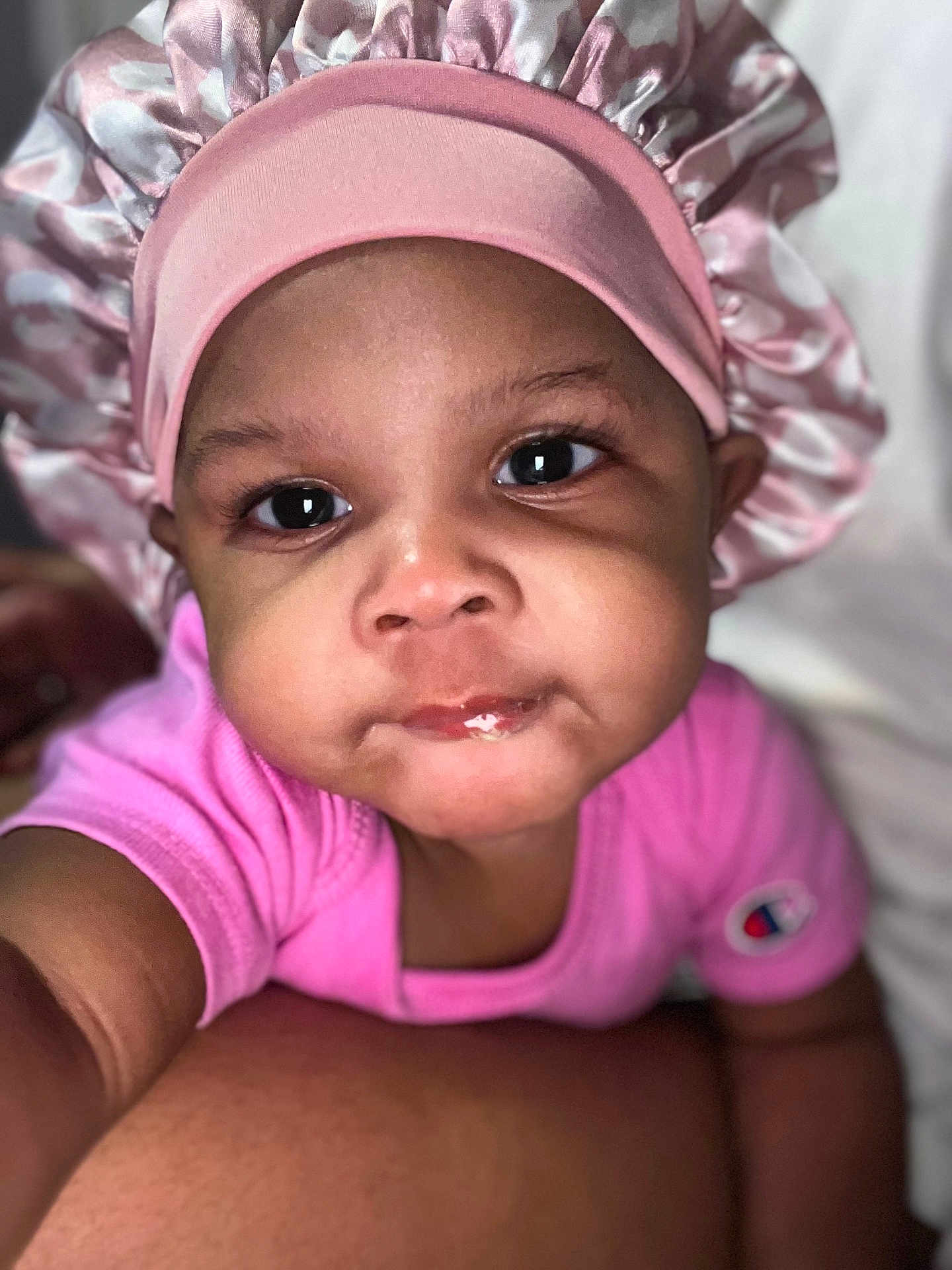 Zureign joined the competition — help win amazing prizes! baby, child, pink_bonnet, pink_shirt, face, portrait, close_up, infant, cute, eyes, skin, headwear, clothing, person, young_child, expression, indoor, human, adorable, baby_face