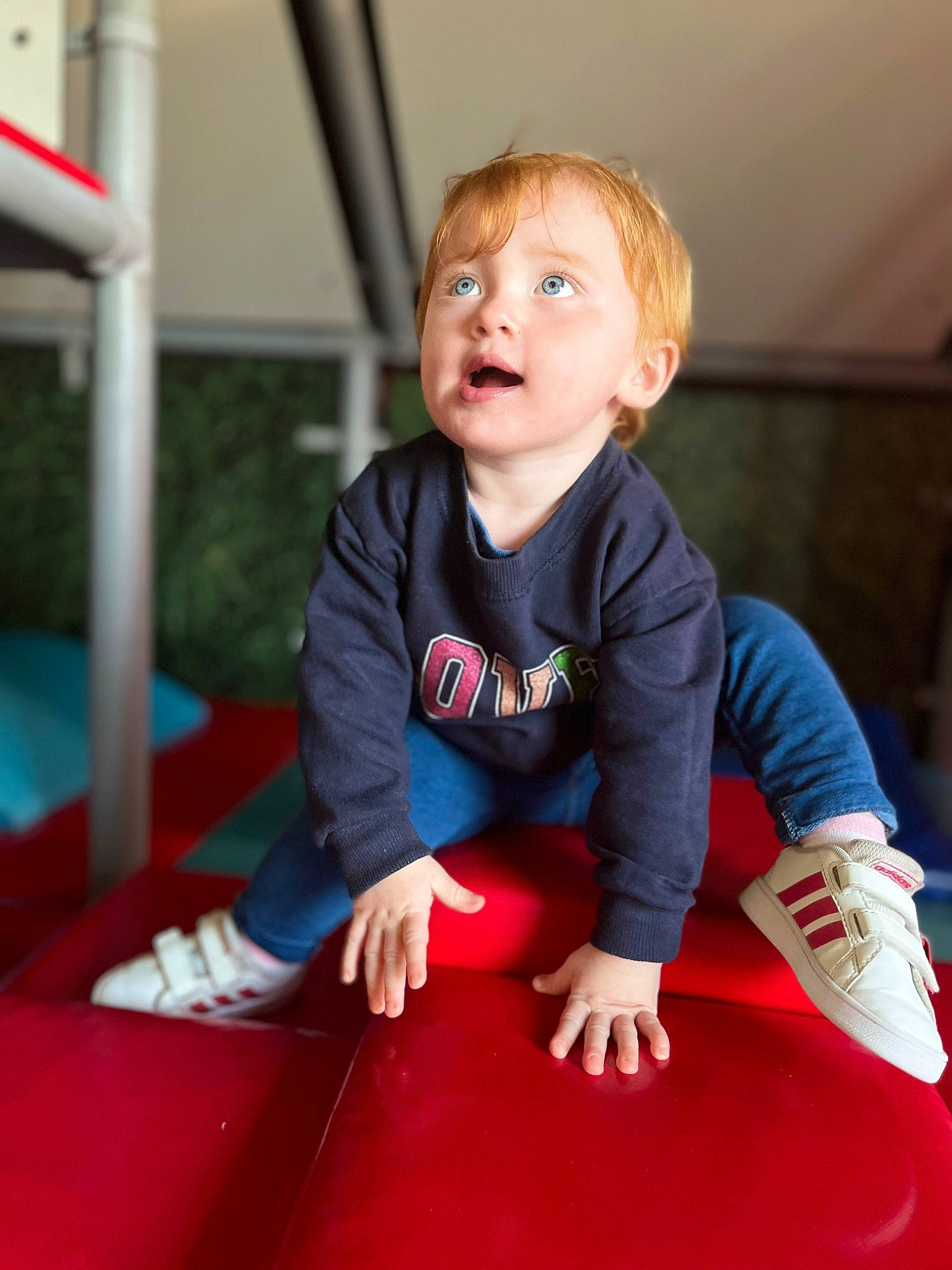 Yväna a rejoint le concours — aidez-le/la à gagner de superbes lots ! baby_toddler_clothing, carmine, child, electric_blue, flooring, fun, grass, happy, human_body, human_leg, leisure, person, play, playground, recreation, sitting, skin, sleeve, smile, surprise