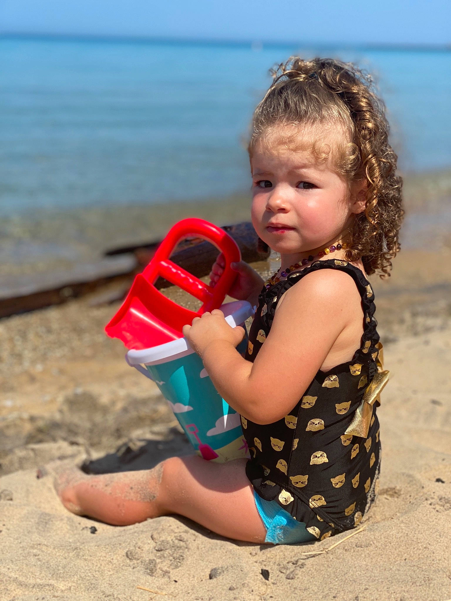 Addy is registered to the contest to win money with this photo: beach, child, fun, happy, holiday, ocean, person, personal_protective_equipment, play, sand, sea, sitting, smile, summer, toddler, vacation, water