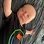 Aiden is registered to the contest to win money with this photo: baby, sleeping, infant, pacifier, blanket, black_clothing, nike_logo, arm, hand, head, face, closed_eyes, bed, rest, comfort, peaceful, young_child, toddler, indoor, portrait