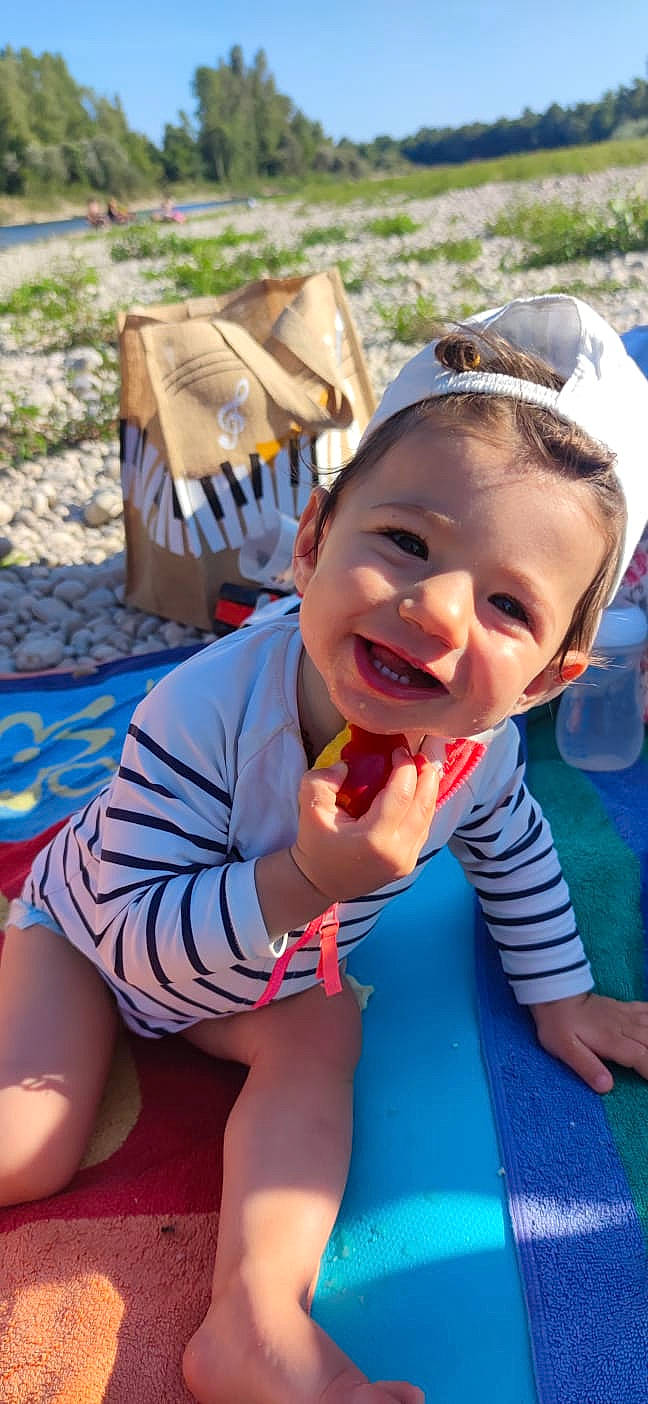 Inaya a rejoint le concours — aidez-le/la à gagner de superbes lots ! baby, baby_toddler_clothing, blue, child, fashion_accessory, fun, grass, happy, joy, laugh, leisure, mouth, person, play, recreation, sitting, skin, smile, summer, thigh