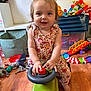 Cassy a rejoint le concours — aidez-le/la à gagner de superbes lots ! baby, child, clothing, colorful, cute, floor, fun, girl, happy, home, indoor, person, pigtails, plastic_toy, playtime, smiling, toddler, toy_car, toys, wooden_floor