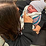 Elias joined the competition — help win amazing prizes! baby, care, clothing, comfort, couch, cradling, face, hair, hand, holding, hospital_blanket, indoor, newborn, person, seated, skin, sleeve, striped_cap, tender_moment, woman