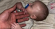 Elias is registered to the contest to win money with this photo: baby, sleeping, hand, pacifier, blanket, soft_toy, infant, cozy, bedtime, close_up, skin, comfort, rest, newborn, child, parent, love, protection, indoor, toddler