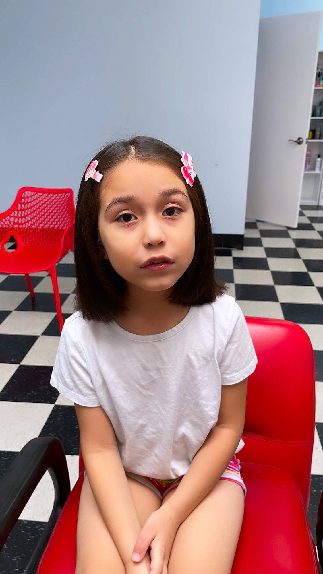 Dahlia is registered to the contest to win money with this photo: audio_equipment, black_hair, brown_hair, chair, child, chin, eyelash, fashion_design, fun, hair, happy, human_leg, leisure, long_hair, person, pink, red, sitting, skin, sleeve