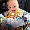 baby, child, infant, smiling, sitting, portrait, face, hands, striped_clothing, activity_seat, baby_toy, colorful, indoor, close_up, happy, playful, fabric, cushion, head, photography