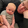 Aubrey is registered to the contest to win money with this photo: baby, adult, couch, striped_clothing, sleeping, curious, tongue_out, indoor, window_blinds, hand, skin, person, resting, close_up, casual, relaxed, infant, seated, family, home