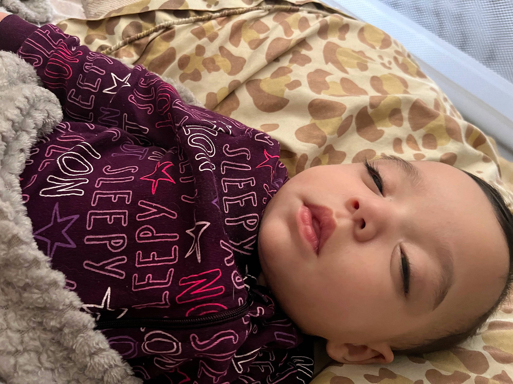 Flora is registered to the contest to win money with this photo: baby, baby_toddler_clothing, beauty, bedding, carmine, cheek, child, close_up, comfort, eyelash, face, fashion_accessory, linens, magenta, pattern, person, skin, sleeve, toddler, wood