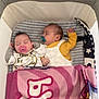 baby, sleeping, pacifier, blanket, bassinet, infant, cozy, cute, toddler, clothing, striped, pink, yellow, white, indoor, resting, peaceful, child, napping, two_babies