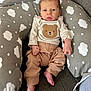 baby, infant, child, cushion, cloud_pattern, bear_design, clothing, pants, long_sleeve, barefoot, indoor, sofa, comfort, cute, portrait, person, small_hands, small_feet, relaxing, cozy